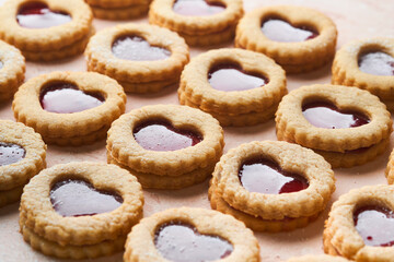 Obraz na płótnie Canvas Traditional Linzer cookie with strawberry jam and powder sugar on pink beautiful background. Top view. Traditional homemade Austrian sweet dessert food on Valentines Day. Holiday snack concept.