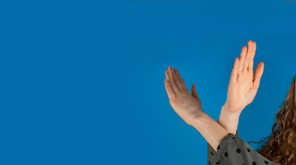 Break the bias symbol of woman's international day. The arms of a girl   are crossed on a blue background.  