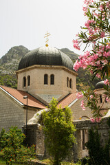 Fototapeta na wymiar View of the old church and mountains on a summer day. Kotor. Montenegro. Location vertical.