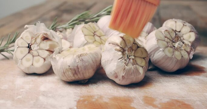 Fresh garlic brushed with olive oil before roasting. Preparing appetizers