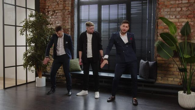 Three men in business suits are dancing and having fun. Celebration for office workers