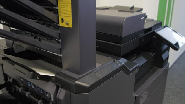 Young man copies documents on a copying system in office