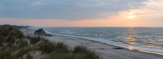Panoramic seascape with beach house and sand dunes