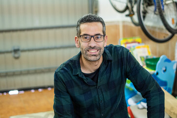 Close up of a smiling man in the garage of a house.