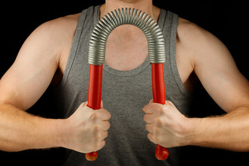 Athletic man bends an expander. Strength and power