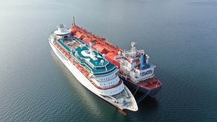 Aerial drone photo of abandoned lng tanker and small cruise liner anchored in industrial Gulf of...