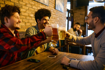 Happy Lebanese man and his Caucasian friends have fun while toasting with beer in a pub.