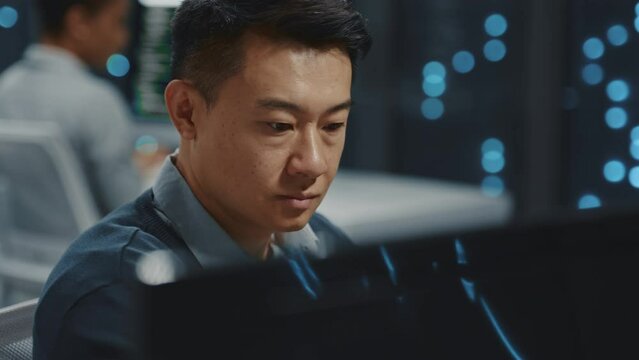 Chinese IT administrator performing server data cloud computing backup operation and collaboration in business office. Data center. Professional staff.