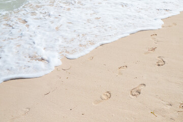 Footprints of bare feet and shore foam