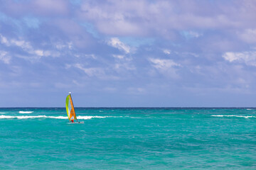 Small sail catamaran goes at the ocean water