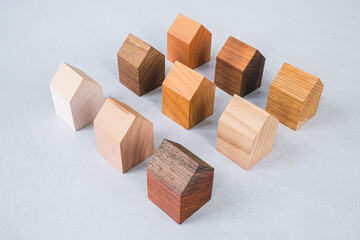 Group of similar wooden tiny toy houses. Wooden models of buildings as conceptual images for real estate topics.