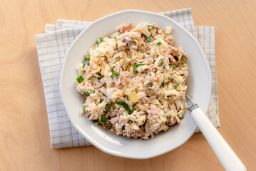 Salad with rice, tuna, egg, pickled cucumber, and chives.