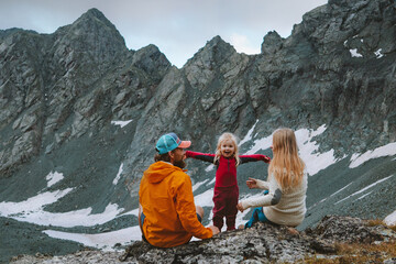 Child girl hiking with parents in mountains family travel summer vacations camping outdoor...