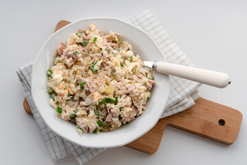 Salad with rice, tuna, egg, pickled cucumber, and chives.