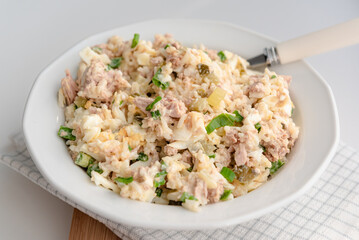 Salad with rice, tuna, egg, pickled cucumber, and chives.