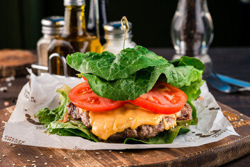 burger with cutlet and cheese wrapped in lettuce leaves without a bun
