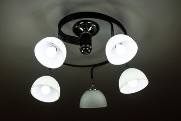 A beautiful chandelier that shines dimly in a dark room.