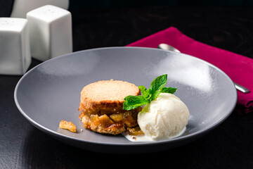 apple pie on plate with a scoop of vanilla ice cream