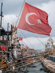 The Turkish flag flies over a boat in the old town harbour ,Antalaya ,Turkey .