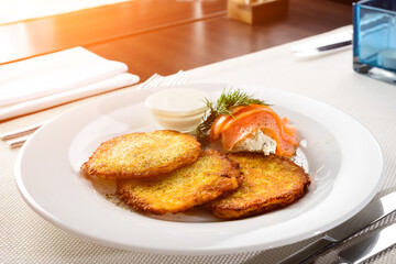 Traditional Belarus potato pancakes draniki with sour cream in