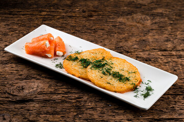 Fried potato pancakes with salmon and sour cream