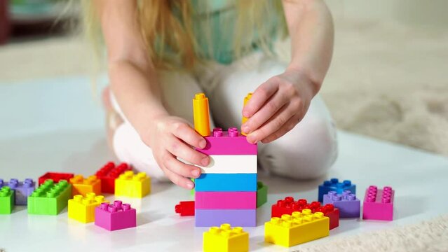 Child girl collects the constructor. Children's educational games.