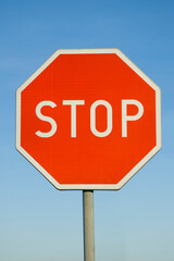 Stop sign isolated against blue sky.