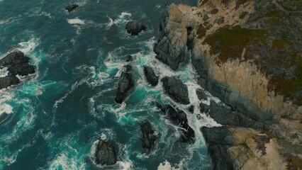 Crystal clear turquoise water, waves crashing on the rocky shore, and the ruins