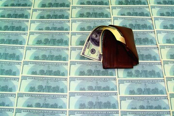 unclosed leather brown wallet with a thick stack of dollars on the background of dollar bills