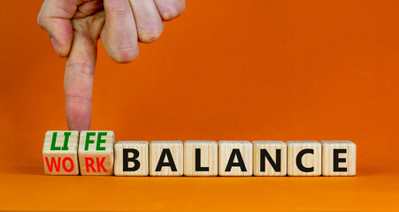 Work life balance symbol. Businessman turns cubes and changes concept words Work balance to Life...