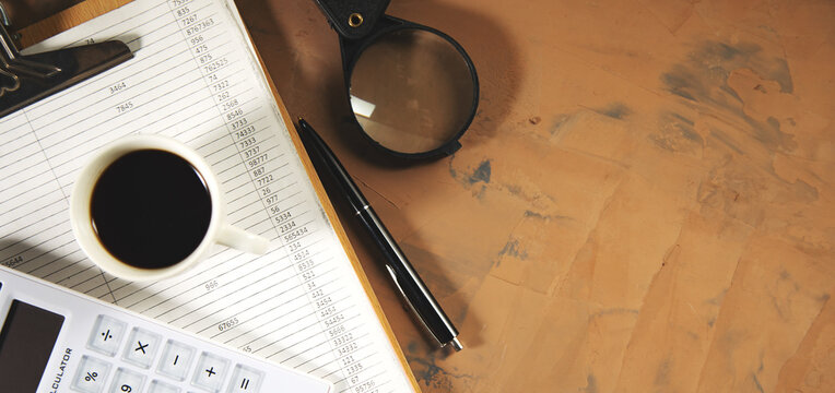 document with calculator and magnifier on working table