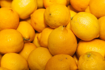 Background from a large number of whole unpeeled lemons.