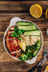 Keto lunch bowl. Grilled chicken with cauliflower rice, broccoli and cucumber.
