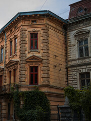 Naklejka premium autumn old Europe city living district apartment building rustic stone exterior facade of front side vertical photography on fall season rainy gray day time
