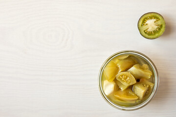 Pickled unripe green tomatoes. Canned homemade home-grown food in jars.