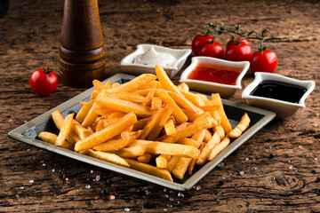 Delicious french fries and ketchup. fast unhealthy food background, closeup on wooden background
