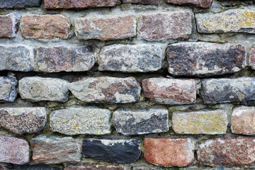 Fototapeta premium The rough textured surface of the wild stone wall. Background.
