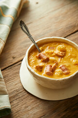 Mote pata is a traditional ecuadorian soup made from mote, pork, sausage and sambo seeds. It’s served on a white plate with a rustic, wooden and homey background. 