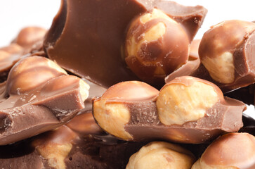 Chocolate with whole hazelnuts close up on white background
