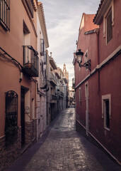 Old street in Relleu town with its historic church in the background. Located in the province of Alicante, Spain