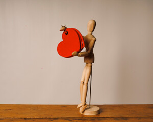 Wooden mannequin with red flower