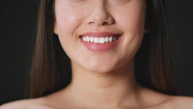 Dentistry and oral hygiene. Unrecognizable woman smiling, demonstrating perfect smile and white teeth, slow motion