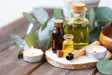 Fototapeta na wymiar Assortment of natural oils in glass bottles on wooden background. Concept of pure organic ingredients in cosmetology. Bath accessories, atmosphere of harmony, relax. Close up macro. Healthy lifestyle