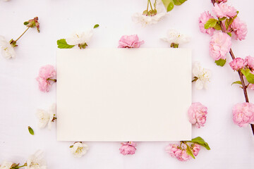 Feminine stationery card mockup with spring white and pink delicate flowers. Romantic, wedding, birthday, invitation, mother's day mock up card concept. Copy space. Top view.