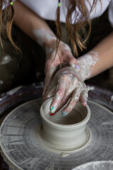 Young woman doing handmade pottery on the potter's wheel. Artist at work
