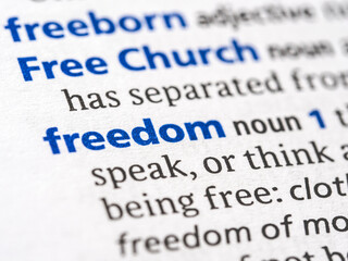 Freedom - English dictionary definition of the word - photo of a dictionary page with paper grain texture - selective focus on the word