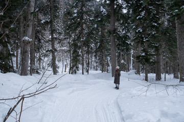 Girl walking in the snowy forest.