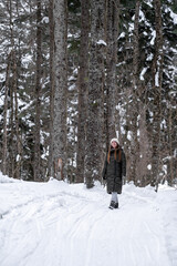 Girl walking in the snowy forest.