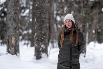 Fototapeta na wymiar Girl walking in the snowy forest.