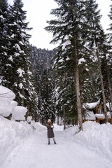 Girl walking in the snowy forest.